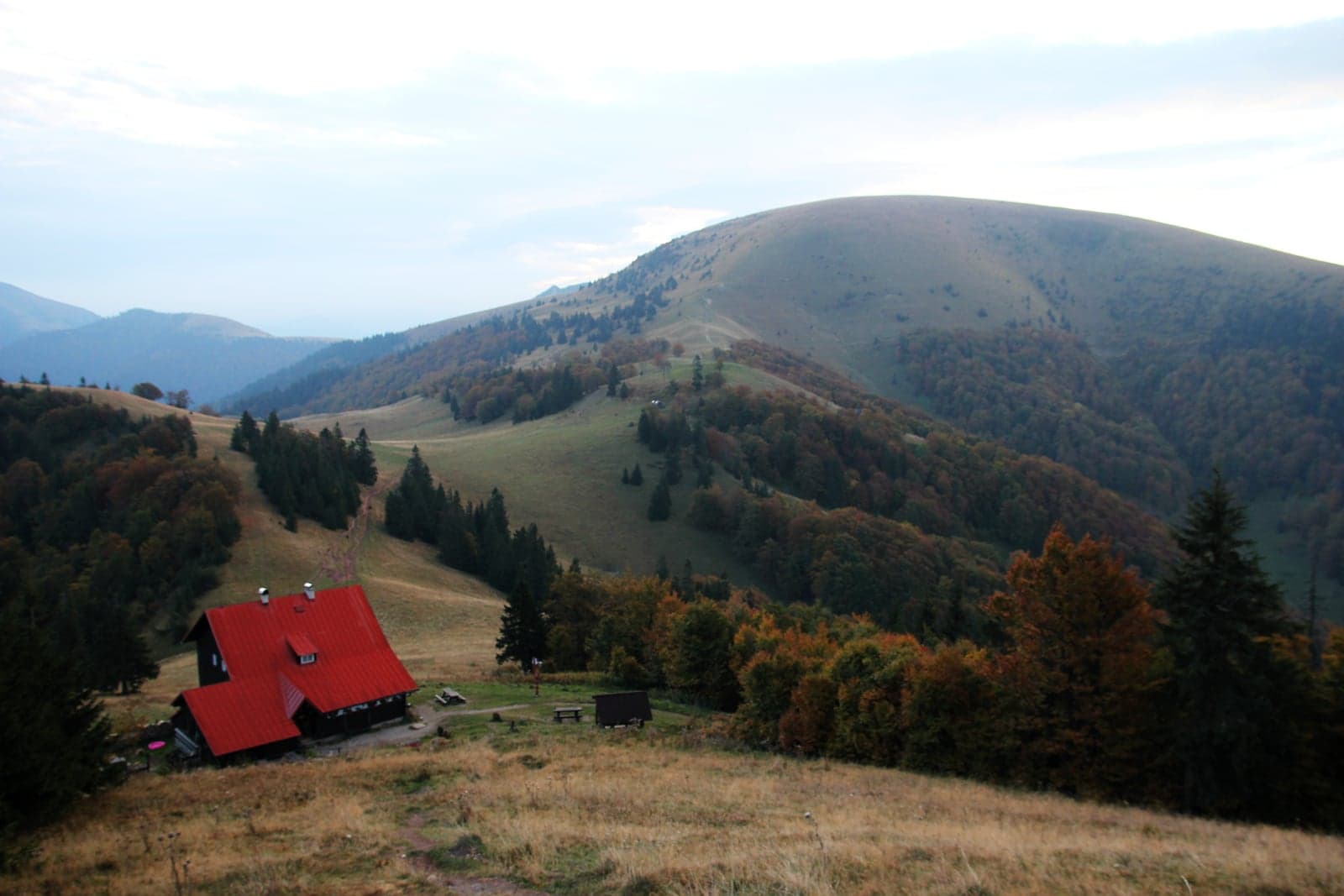 Zaokrąglony szczyt Ploskiej z Chatą pod Borišovom na pierwszym planie