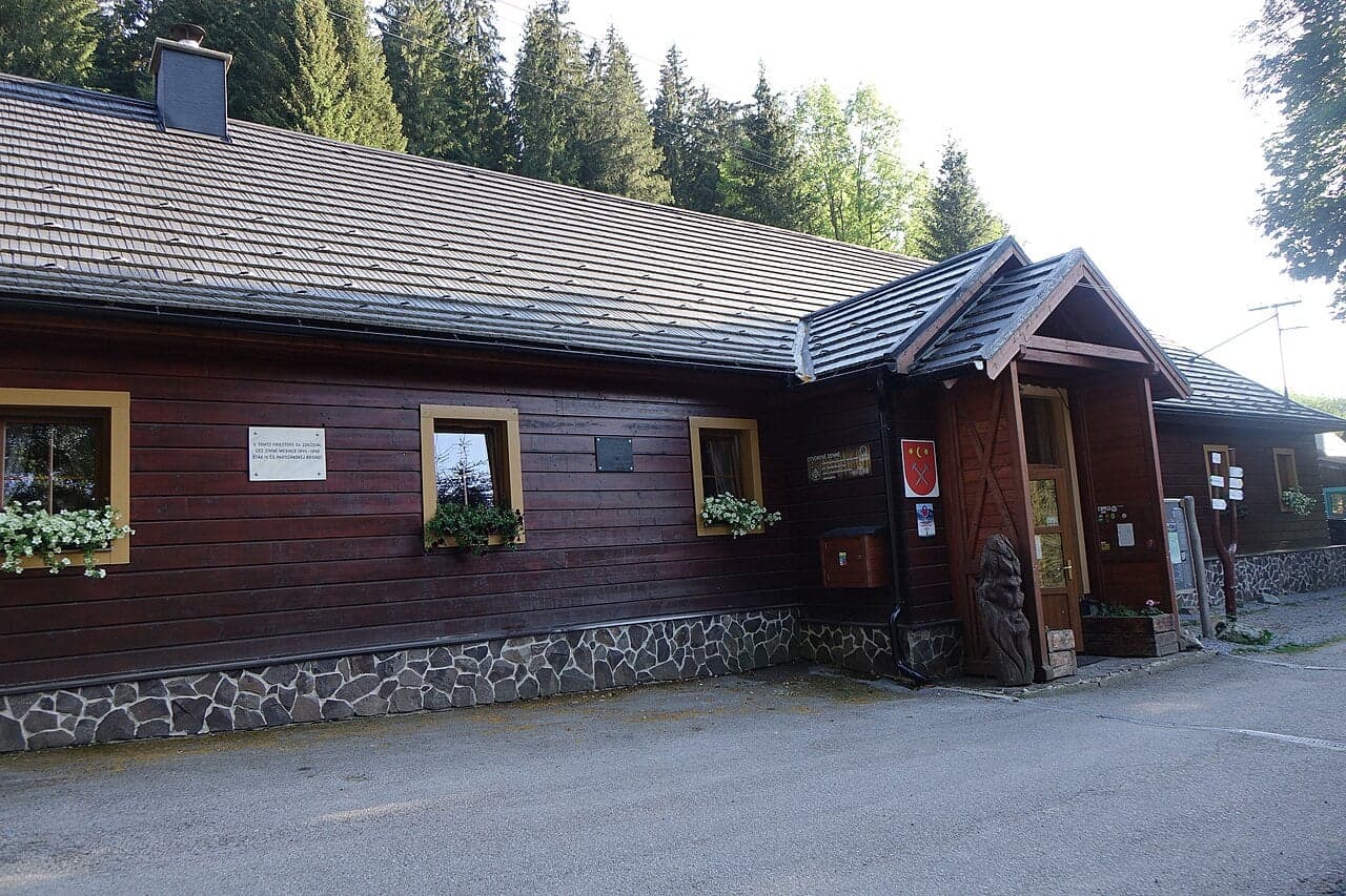 Drewniany budynek Chaty Magurka z wejściem do restauracji pod lasem